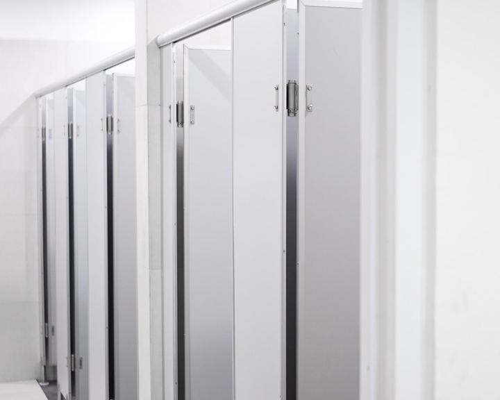 Commercial restroom with a row of toilet partition stalls