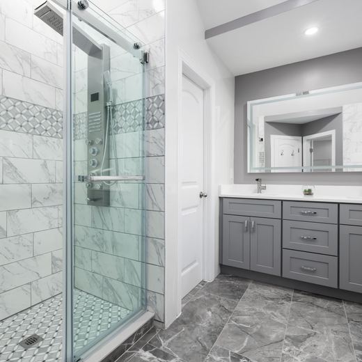 Bathroom remodel idea: gray double vanity beside a glass walk-in shower